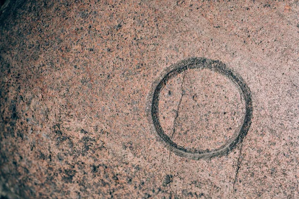 O sign carved on a stone. Letter of the alphabet on granite. Stone engraving