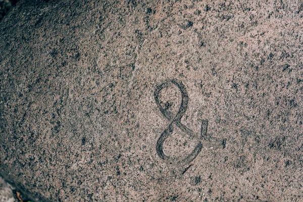 Ampersand sign carved on the stone. Symbol on granite. Stone engraving