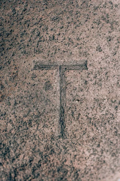 Letter T carved on the stone. Letter from the alphabet on granite. Stone engraving