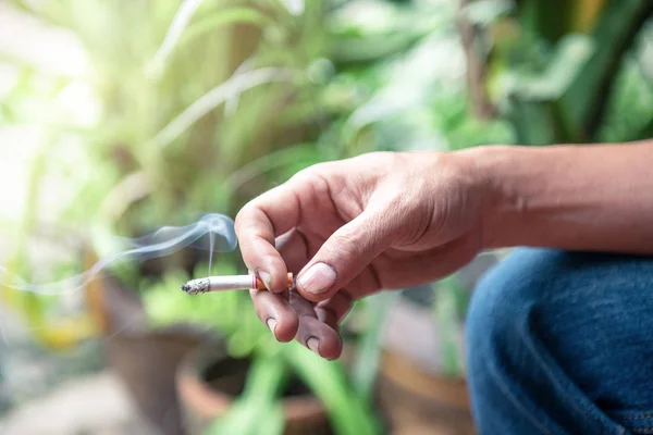 duman ile sigara tutan el