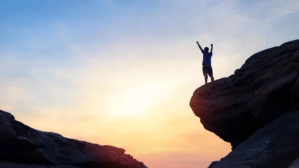siluet adam dağın tepesinde el kaldıran , başarı kavramı