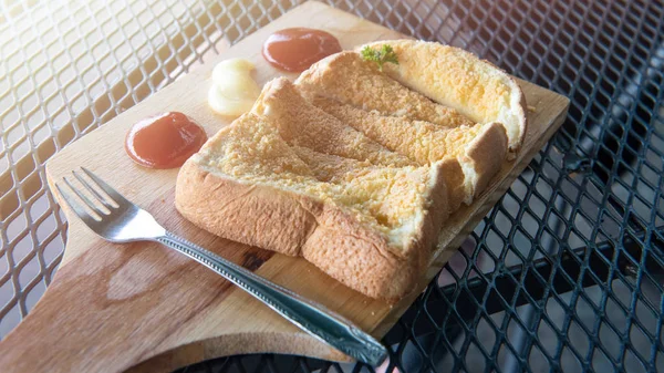 Tahta tabakta mayonez ve domates soslu gevrek sarımsaklı ekmek 