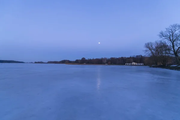 Moon over frozen lake in Niasvizh, Belarus