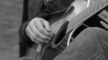 Parkta siyah beyaz gitar çalmak