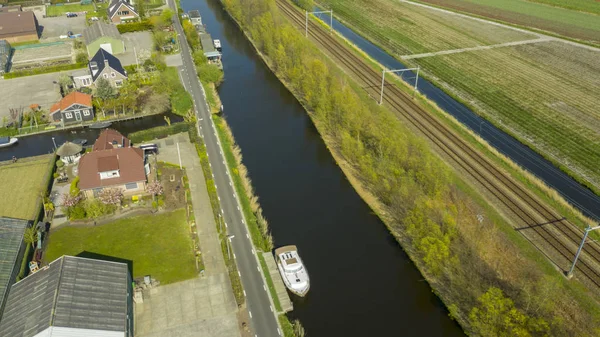Vista aérea del pueblo holandés, canales, carretera ferroviaria y campos de bulbos de tulipán —  Fotos de Stock