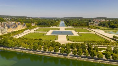 Fransa'da Paris yakınlarındaki ortaçağ tarihi kraliyet av kalesi Fontainbleau ve beyaz kuğular ile göl havadan görünümü