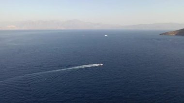 Bir su kayakçısını çeken motorlu teknenin hava görüntüsü. Elounda, Girit, Yunanistan