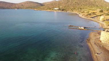 Koyu mavi bir denizde, motorlu bir teknenin havadan görünüşü. Kolokitha Adası, Girit, Yunanistan
