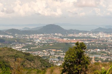 Görkemli dağlarla ve yemyeşil yeşilliklerle çevrili canlı bir sahil şehrinin çarpıcı manzarasının tadını çıkarın.