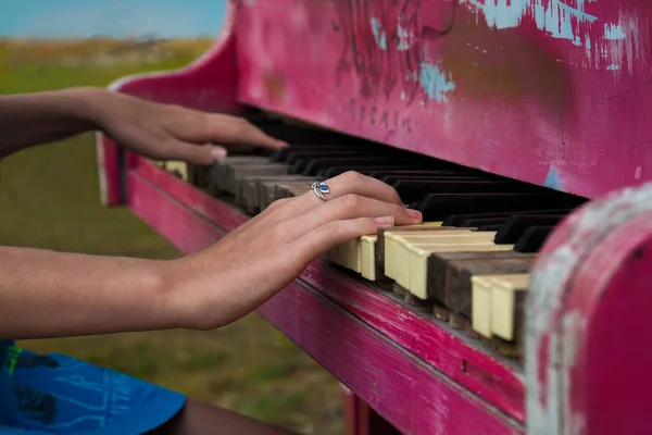 Broken pink piano and pianist\'s hands