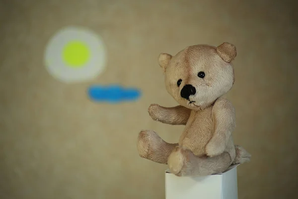 Kağıt güneş ve bulutların bir arka plan üzerinde oturan Ev yapımı Teddy ayı oyuncak