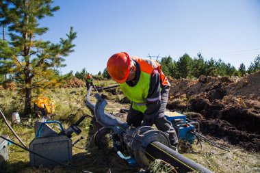 iki işçi daha sonra doğal gaz olacak borular, bağlamak