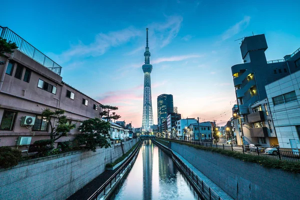 Tokyo, Japonya - 22 Haziran 2018: Tokyo Skytree, Sumida Ward kentsel gece sahne. Tokyo Skytree Kulesi kanalın üzerine düşünceler. Ağaç Gökyüzü Tokyo Tokyo ünlü dönüm noktası biridir.