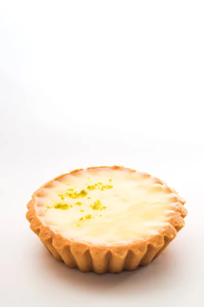 One single lemon tart, isolated on white.
