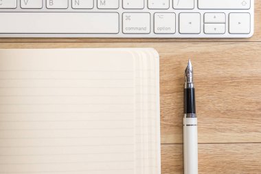 Ofis Masası Not defteri, klavye ve dolma kalem ile. Yukarıdan görüntülemek