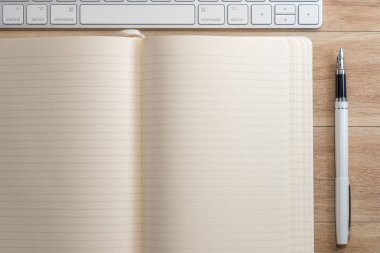 Ofis Masası Not defteri, klavye ve dolma kalem ile. Yukarıdan görüntülemek