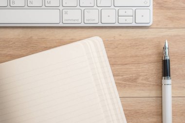 Ofis Masası Not defteri, klavye ve dolma kalem ile. Yukarıdan görüntülemek