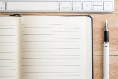 Ofis Masası Not defteri, klavye ve dolma kalem ile. Yukarıdan görüntülemek