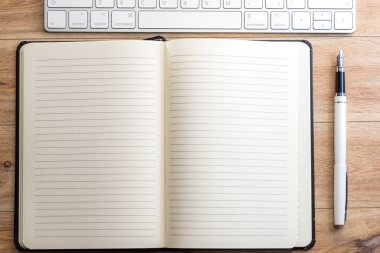 Ofis Masası Not defteri, klavye ve dolma kalem ile. Yukarıdan görüntülemek