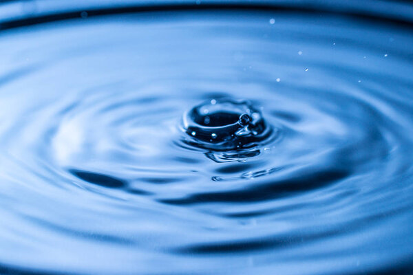 water drop splash in a glass blue colored