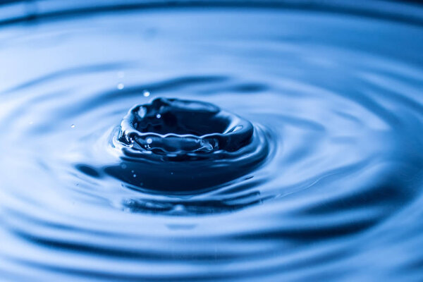 water drop splash in a glass blue colored