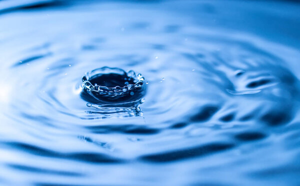 water drop splash in a glass blue colored
