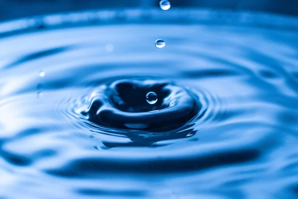 Σταγόνα Νερό Βουτιά Ένα Γυάλινο Μπλε Χρώμα — Φωτογραφία Αρχείου