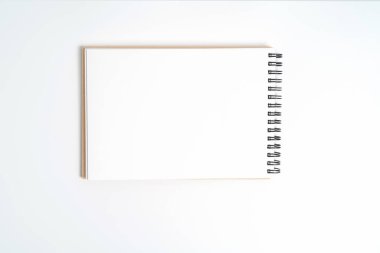 Bir bahar üstünde bir defter. Beyaz arka plan üzerinde izole.