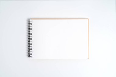 Bir bahar üstünde bir defter. Beyaz arka plan üzerinde izole.