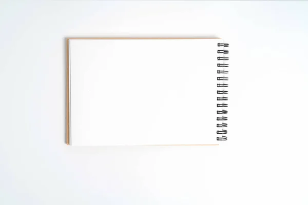 En anteckningsbok på en fjäder. Isolerad på vit bakgrund. — Stockfoto