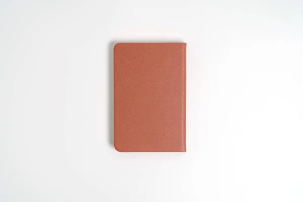 Вид зверху порожній помаранчевий шкіряний щоденник на білому столі — стокове фото