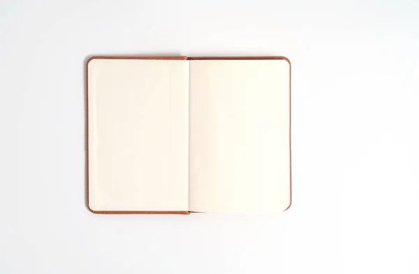 Pohled shora prázdný oranžový zápisník na bílém stole — Stock fotografie