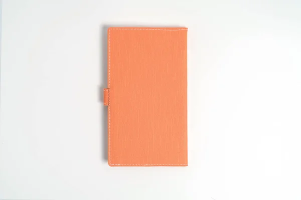Pohled shora prázdný oranžový zápisník na bílém stole — Stock fotografie