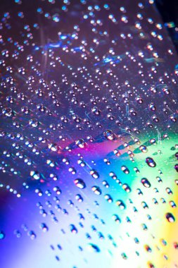 Dvd ortamında su damlaları, renkli arka planda su damlaları