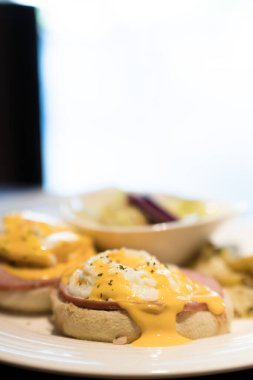 İskoçya 'da hafta sonu vejetaryen kahvaltısı. Ispanaklı ve sarı Hollandaise soslu ev yapımı keklerin üzerine iki yumurtalı Benedict..