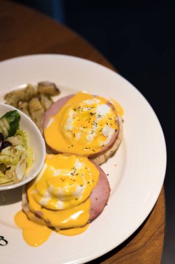 İskoçya 'da hafta sonu vejetaryen kahvaltısı. Ispanaklı ve sarı Hollandaise soslu ev yapımı keklerin üzerine iki yumurtalı Benedict..