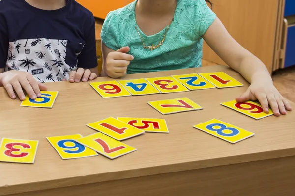 Los niños están jugando. Juegos educativos. Un niño en el jardín de infantes. Las manos de un niño. Matemáticas. Tarjetas para el desarrollo — Foto de Stock