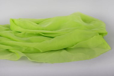 Gri zemin üzerine yeşil kumaş. İpek kumaş. yeşil renkli ince yeşil kumaş. İpek saten veya kadife dokular. Zümrüt veya yeşil ipek arka plan