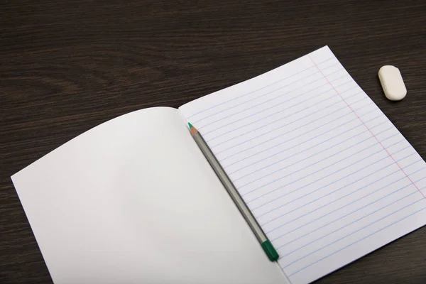 学校のノート用紙。ラインと鉛筆のノート。茶色の背景にノートブックを開きます。計画。文房具 ロイヤリティフリーのストック画像