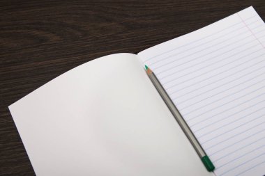 Okul Defter kağıdı. turuncu işaretler. Satır ve kalem defter. kahverengi arka planda açık dizüstü bilgisayar. Planlama. Kırtasiye