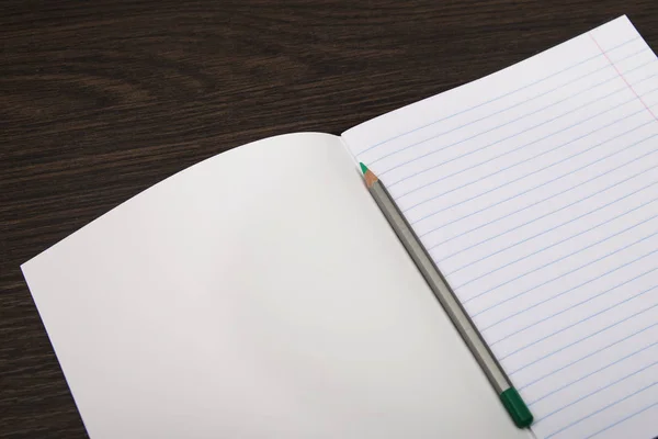 Okul Defter kağıdı. turuncu işaretler. Satır ve kalem defter. kahverengi arka planda açık dizüstü bilgisayar. Planlama. Kırtasiye