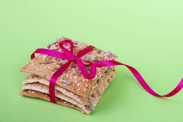 Yeşil arka planda ev yapımı kurabiyeler. bant ile diyet çerezleri. Ayçiçeği, keten ve susam ile Gevrek ekmek