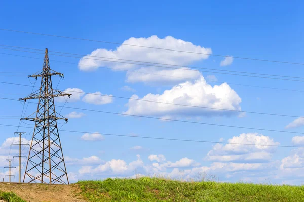 Bulutları ve güç hatları yla gökyüzü. Güzel beyaz bulutlarla mavi gökyüzü. Yeşil tarım arazisinde yüksek gerilim hatları. mavi gökyüzünde cirrus bulutlar ile güneşli bir gün. Güç hattı kulesi