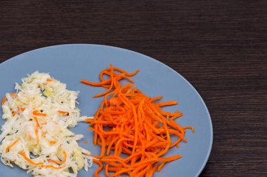 lahana turşusu ve Kore havuçları. Diyet salatası. Gri tabakta Kore havucu. Bir kasede Kore mezesi salatası. Kilo kaybı için ürünler.