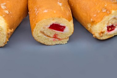 Gri bir tabak üzerinde krem ile sünger rulo. Kalorili yiyecekler. Bir kafede lezzetli tatlı.