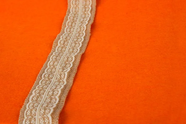 White lace on a brown ribbon. Thin white linen lace. sewing supplies. — Stock Photo, Image