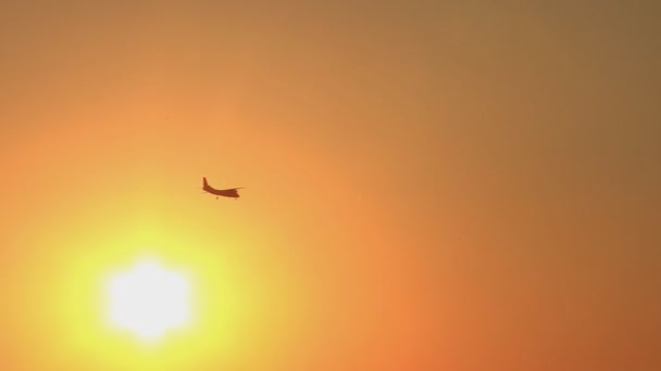 Avion vole à travers le ciel pendant le beau coucher de soleil 