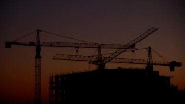 Yüksek katlı karşı gündoğumu, zaman atlamalı arka plan üzerinde bina inşaatı 