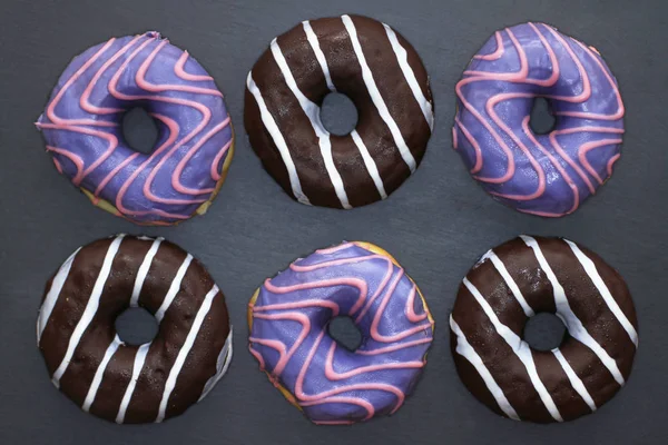 Donat Berwarna Ungu Dan Coklat Dengan Pola Belang Pada Latar — Stok Foto