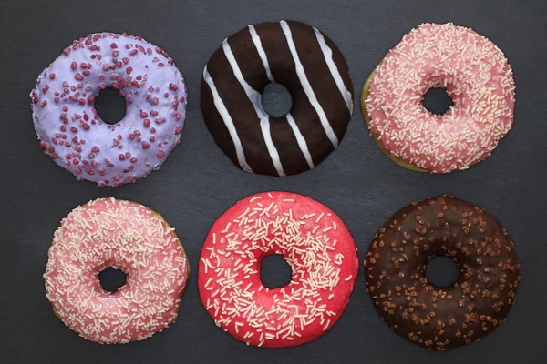 Donuts Cores Diferentes Fundo Escuro Vista Cima — Fotografia de Stock